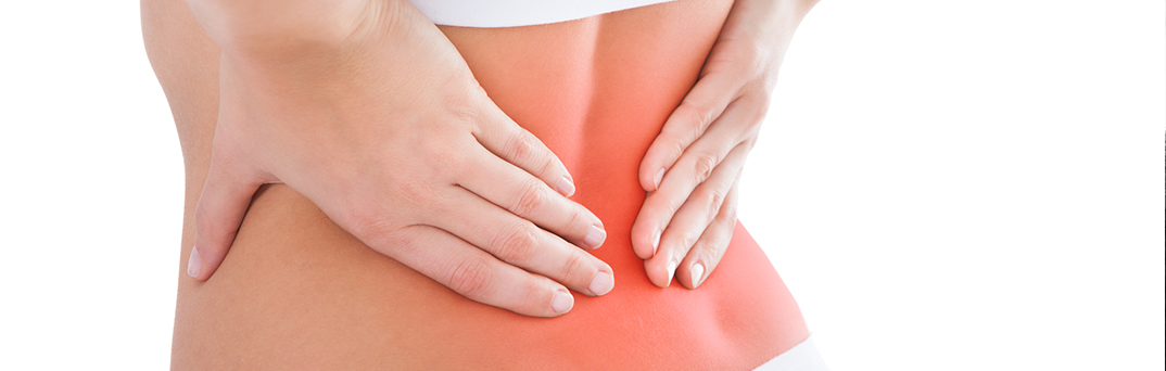 Woman with hands on back in pain.